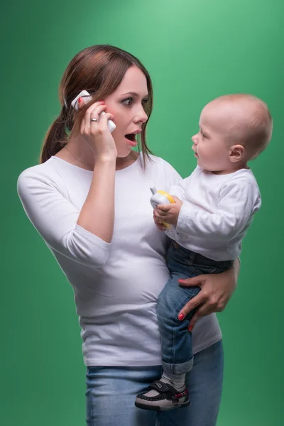 Matka trzyma malucha syna z telefon zabawka — Zdjęcie stockowe