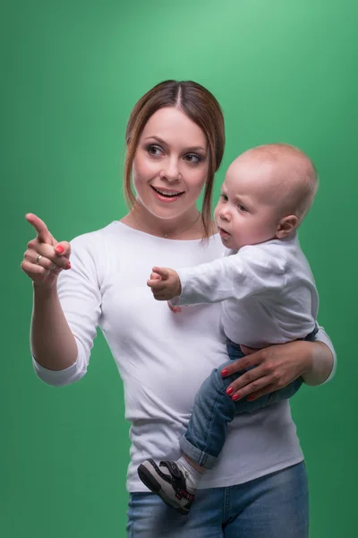 Young mother and her toddler son pointing at something — Stock Photo, Image