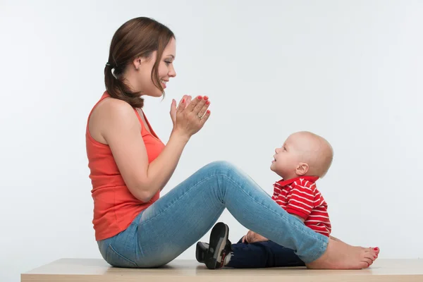 Happy mother and toddler son sitting face to face — Stock Photo, Image