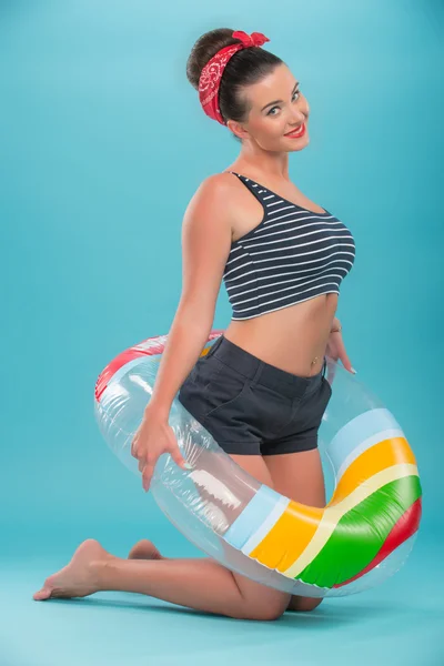 Hermosa chica con bonita sonrisa en estilo pinup acostado en inflata — Foto de Stock