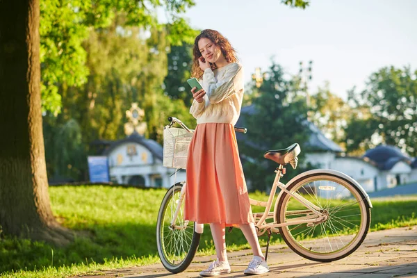 Una foto de una chica con una bicicleta en un parque — Foto de Stock