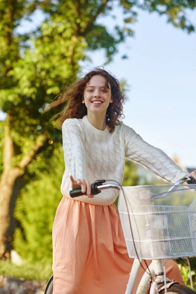 Um bonito fgirl em uma bicicleta sentindo-se bem e sorrindo — Fotografia de Stock