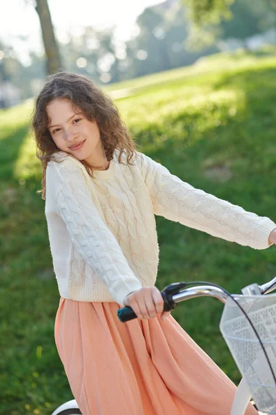 Una foto de una linda chica en una bicicleta en el parque — Foto de Stock