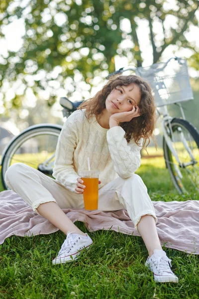 Una chica de blanco sentada sobre una hierba en el parque —  Fotos de Stock