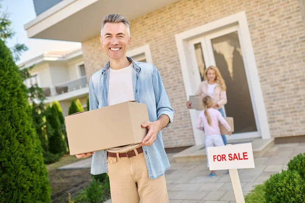 Sonriente hombre sacando la caja de la casa —  Fotos de Stock