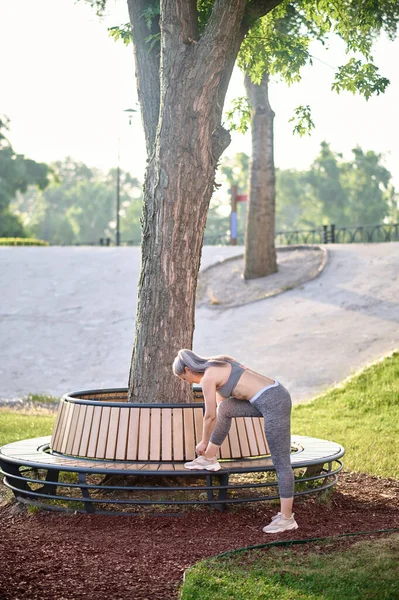 Spor kıyafetli orta yaşlı bir kadın antrenmandan sonra dinleniyor. — Stok fotoğraf