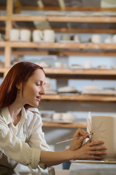 Een mooie vrouw op zoek betrokken bij het schilderen van de pot — Stockfoto