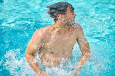Yüzme havuzunda yüzen ve rahat görünen bir adam.