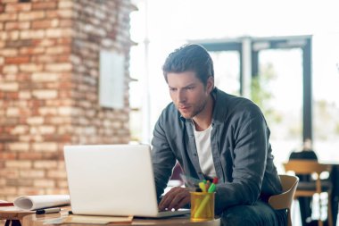 Adam dikkatle dizüstü bilgisayara bakıyor