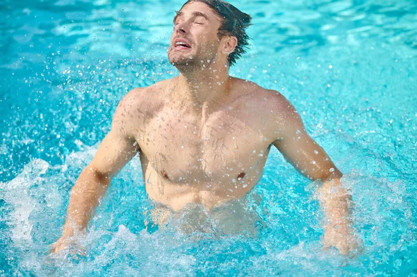 Um homem nadando em uma piscina e olhando relaxado — Fotografia de Stock