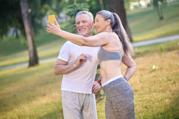 Dospělý šťastný pár dělat selfie a vypadající spokojeně — Stock fotografie