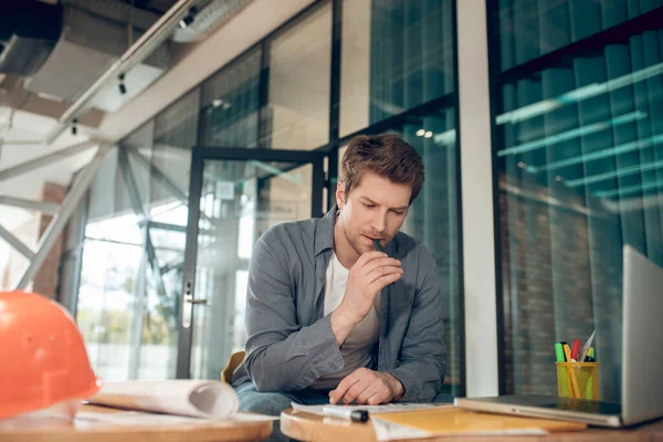 Hombre concentrado reflexionando sobre el plan de construcción en interiores — Foto de Stock