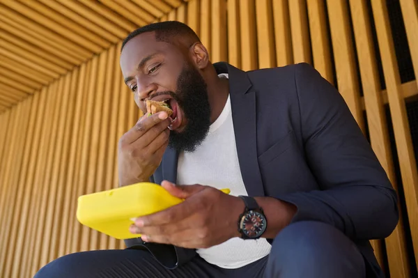 Un hombre sentado en el banco y almorzando — Foto de Stock