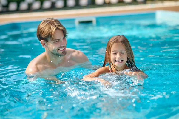 Genç bir baba kızına yüzmeyi öğretiyor. — Stok fotoğraf