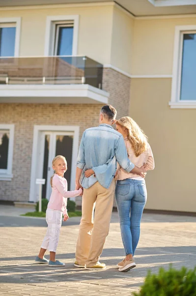 Hombre con esposa e hija admirando un nuevo hogar — Foto de Stock