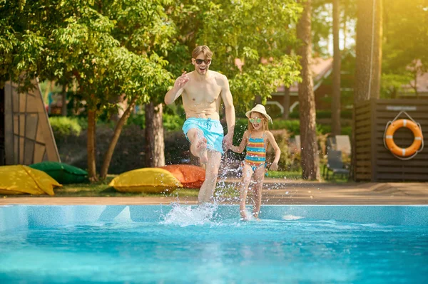 Um pai e uma filha que passam tempo na piscina — Fotografia de Stock