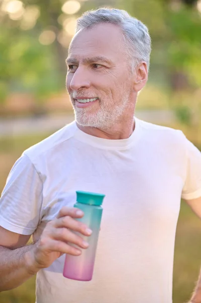 Фотография человека с бутылкой воды в руках — стоковое фото