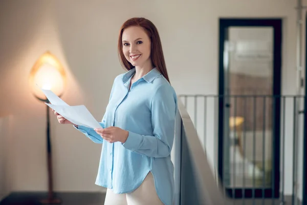 Mulher sorridente com plantas em quarto iluminado — Fotografia de Stock