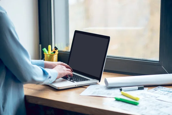 Female hands near laptop keyboard on windowsill — Stock Photo, Image