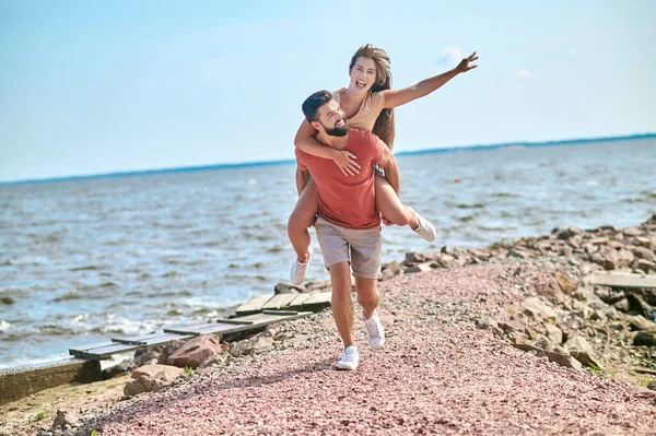 Счастливая пара чувствует себя потрясающе, проводя время на пляже — стоковое фото