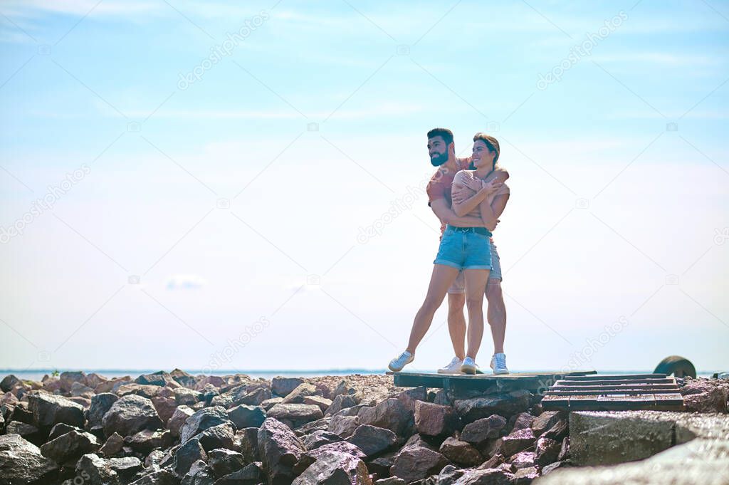 A view of a couple standing near the waterline