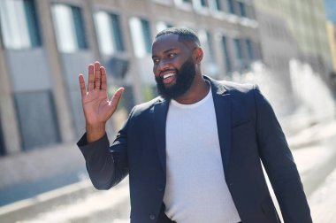 Afro-Amerikalı genç adam gülümsüyor ve mutlu görünüyor.