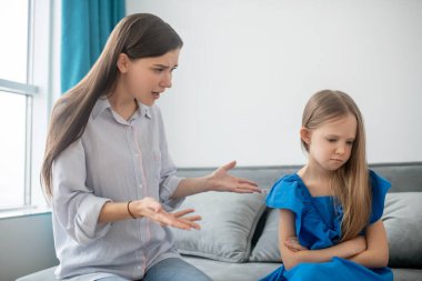 Anne ve kızı arasında bir anlaşmazlık var ve stresli görünüyorlar.