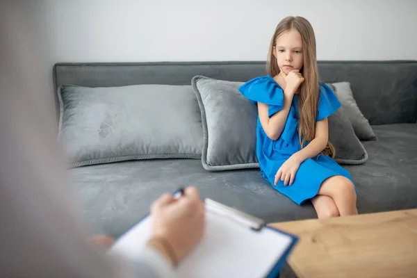Uma menina em um vestido azul ter uma reunião com um psicólogo — Fotografia de Stock