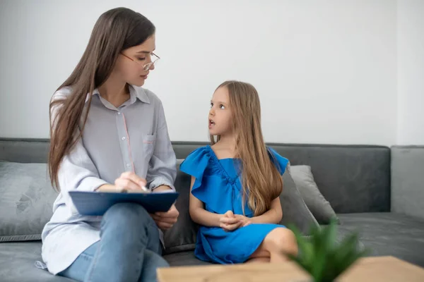 Een meisje in een blauwe jurk die een ontmoeting heeft met een psycholoog — Stockfoto