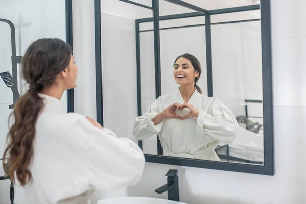 Das Bild einer jungen Frau im Bademantel im Badezimmer — Stockfoto