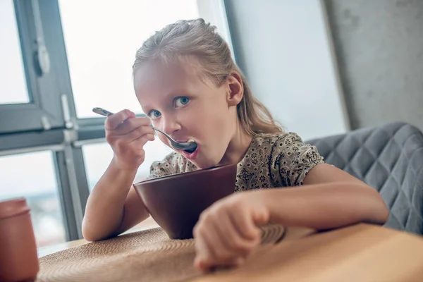 Roztomilé slepé dívka jí snídani a hledá zapojený — Stock fotografie