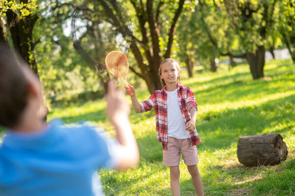 Focused girl with racket and boy back