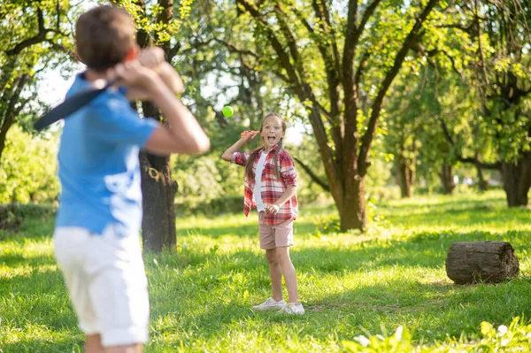 Fille et garçon jouant au badminton dans le parc — Photo