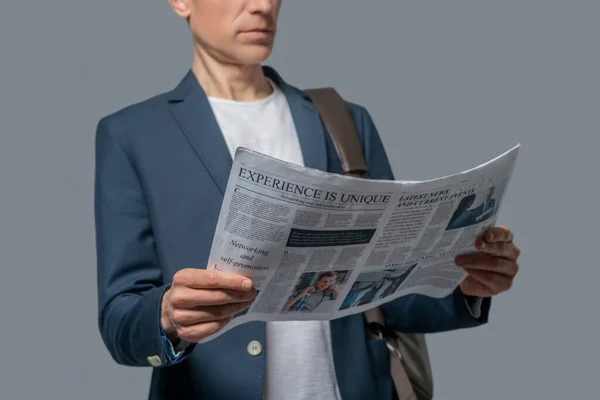 Mann mit Zeitung in der Hand liest Nachrichten — Stockfoto