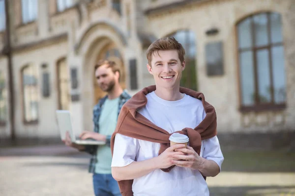 Dos chicos sonrientes en un patio de la universidad luciendo alegres — Foto de Stock