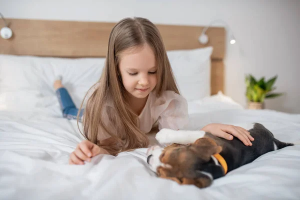 Una linda chica jugando con su cachorro y luciendo feliz —  Fotos de Stock