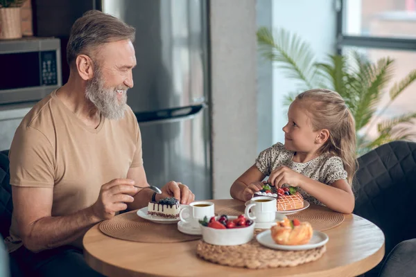 Pappa och hans dotter äter frukost hemma. — Stockfoto