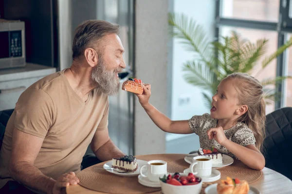 Pappa och hans dotter äter frukost hemma. — Stockfoto