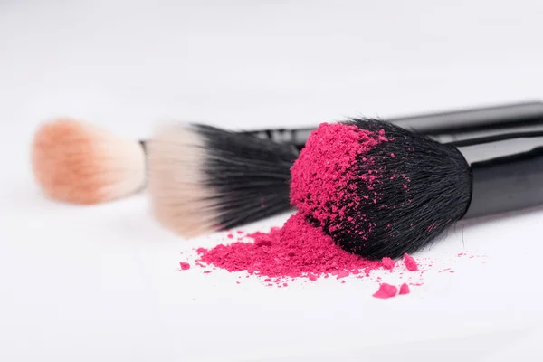 Крупный план профессиональной щетки для макияжа с разбившимся розовым глазом — стоковое фото