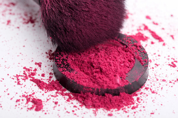 Close-up of  professional  make-up brush with crashed pink eye s