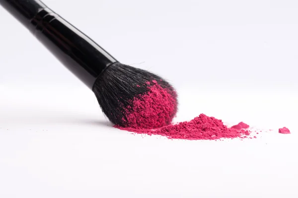 Крупный план профессиональной щетки для макияжа с разбившимся розовым глазом — стоковое фото