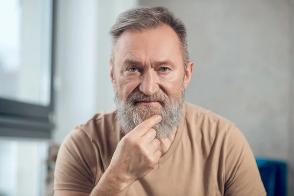 Una imagen de la cintura hacia arriba de un hombre barbudo mirando reflexivo — Foto de Stock