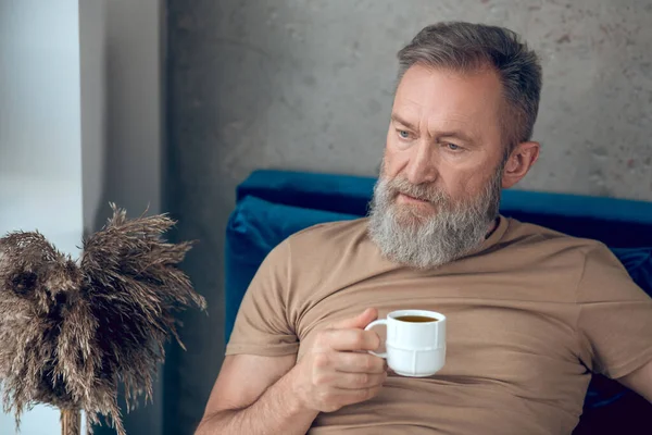 Muž, který si užívá ranní kávu a vypadá uvolněně. — Stock fotografie