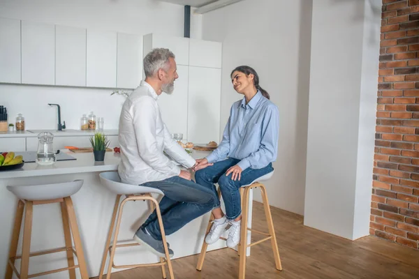 A man and a woman sitting in the kitchen and talking — Stock Photo, Image