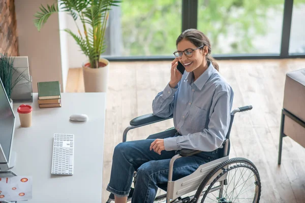 Een gehandicapte jonge vrouw aan de telefoon — Stockfoto