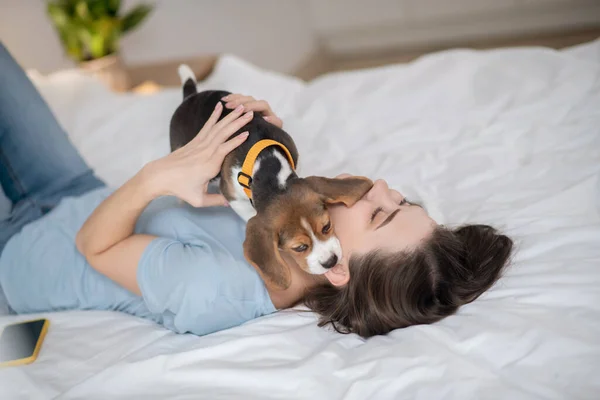 A young woman holding her little cute puppy abd feeling peaceful — Stock Photo, Image