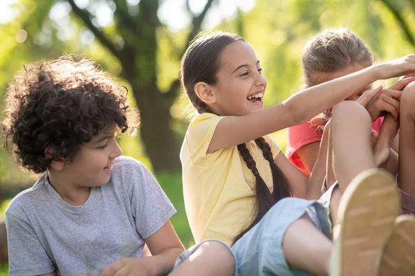 Riéndose chica con coletas y amigos en el parque — Foto de Stock