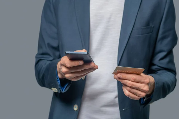 Manos masculinas con smartphone y tarjetas de crédito — Foto de Stock