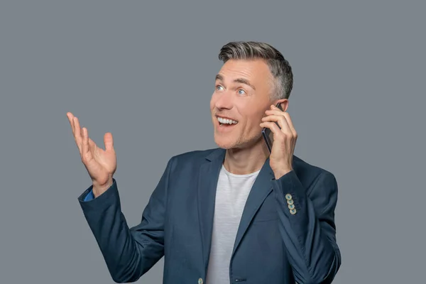 Эмоциональный радостный мужчина разговаривает по смартфону — стоковое фото