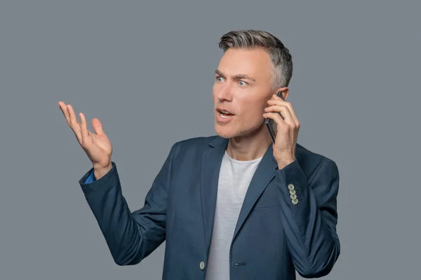 Empresário animado falando por smartphone — Fotografia de Stock